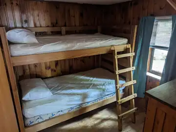 Second bedroom in The Cottage featuring sturdy wooden twin bunk beds, perfect for children