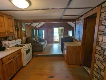 Full kitchen in The Cottage featuring a gas stove, coffee maker, and view into the living area