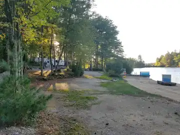 Premium lakefront campsite 117 featuring direct, private walk-on access to a sandy beach